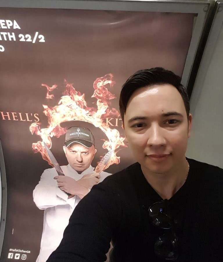 Eugene Charalampous next to a Hell’s Kitchen Greece poster