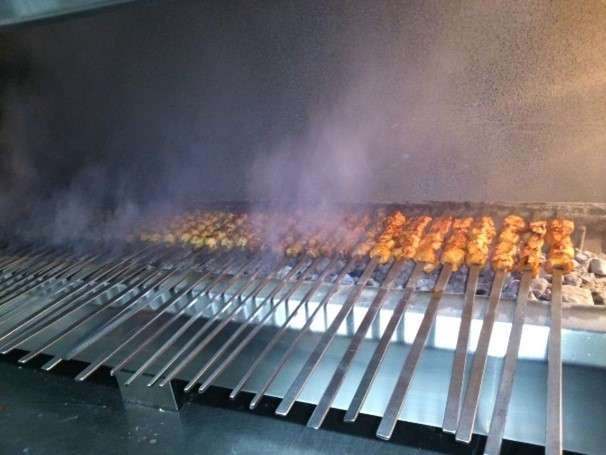 Rows of skewers cooking over a charcoal grill