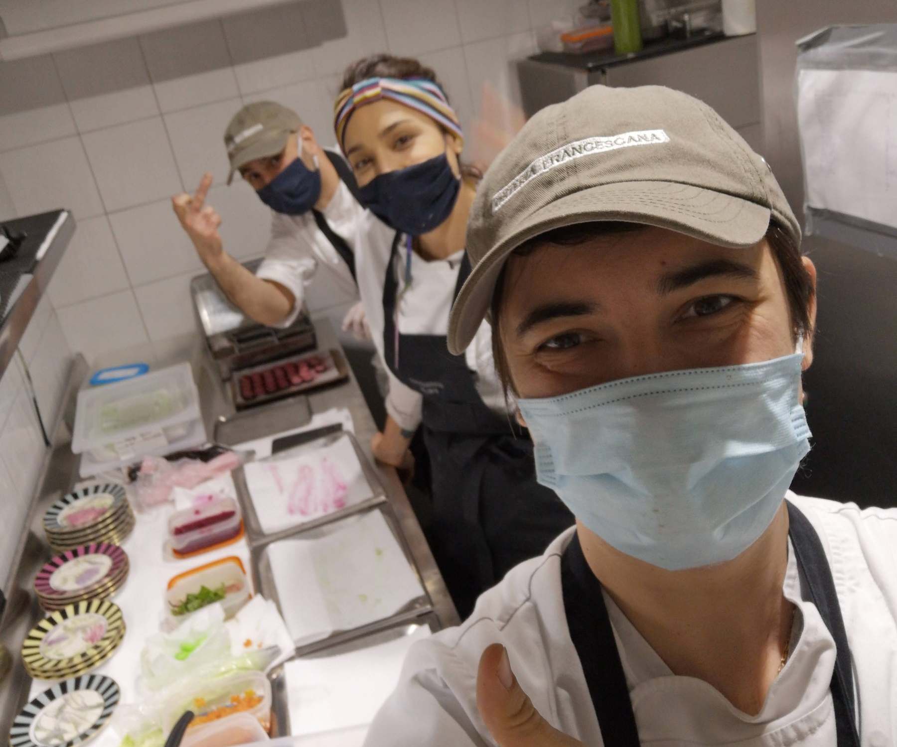 Eugene Charalampous in a cap and mask giving a thumbs up in the Osteria Francescana kitchen